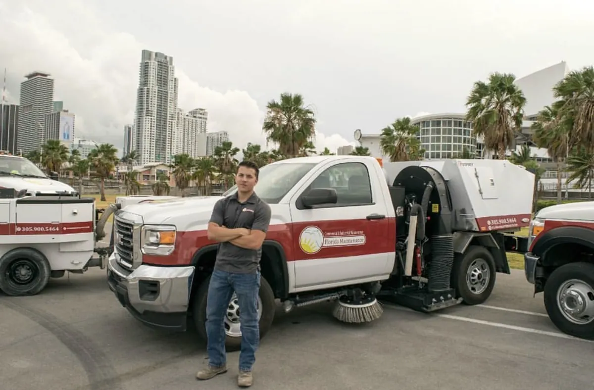Florida Maintenance owner standing in front of company cleaning trucks in Miami