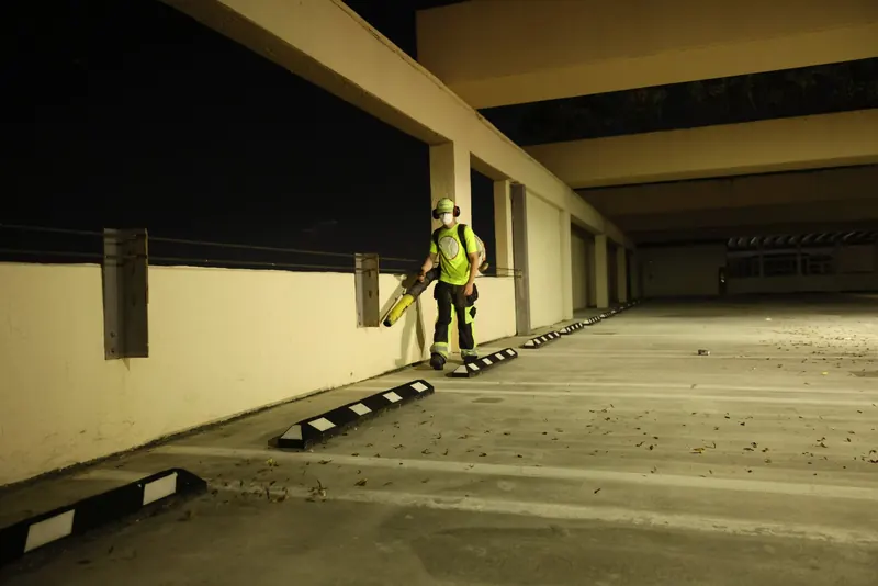 Crew using a backpack blower behind curbs before sweeping
