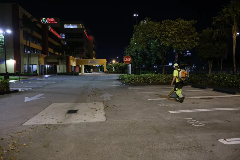 Florida Maintenance crew preparing a parking lot for sweeping