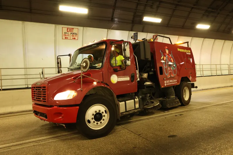 Regenerative air sweeper truck cleaning a tunnel