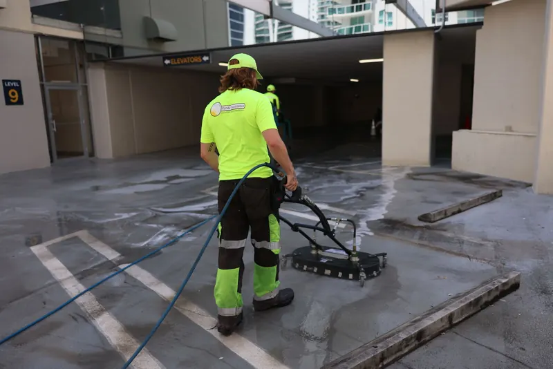 Florida Maintenance technician pressure cleaning a parking garage