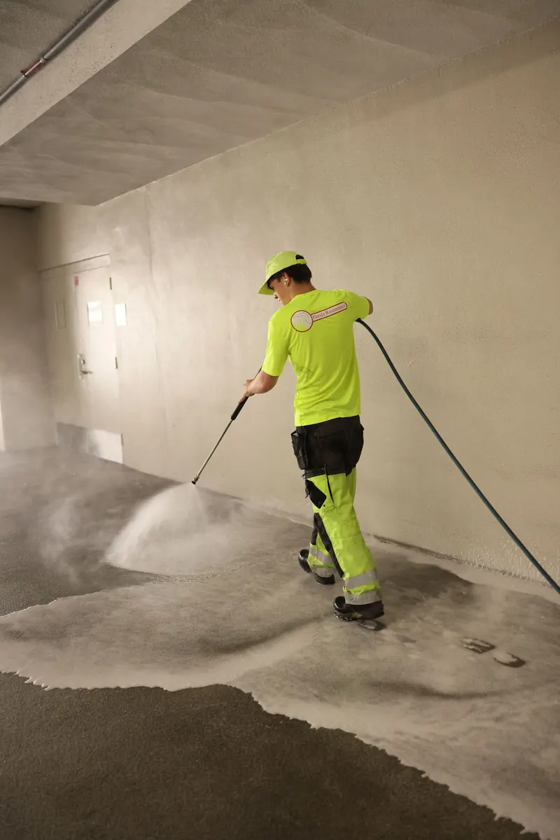 Crew soft washing a parking garage wall